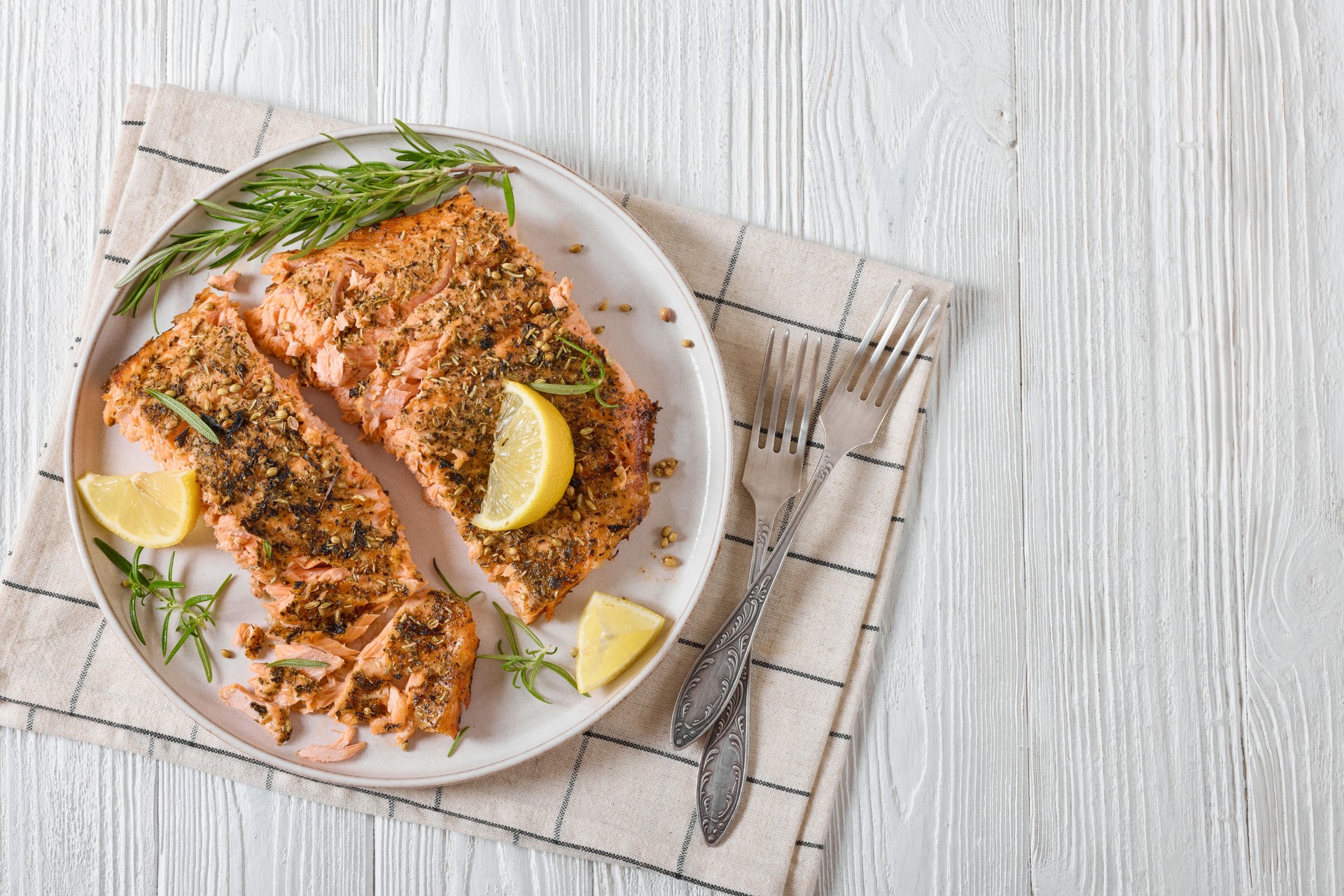 baked salmon fillet with lemon, rosemary on plate